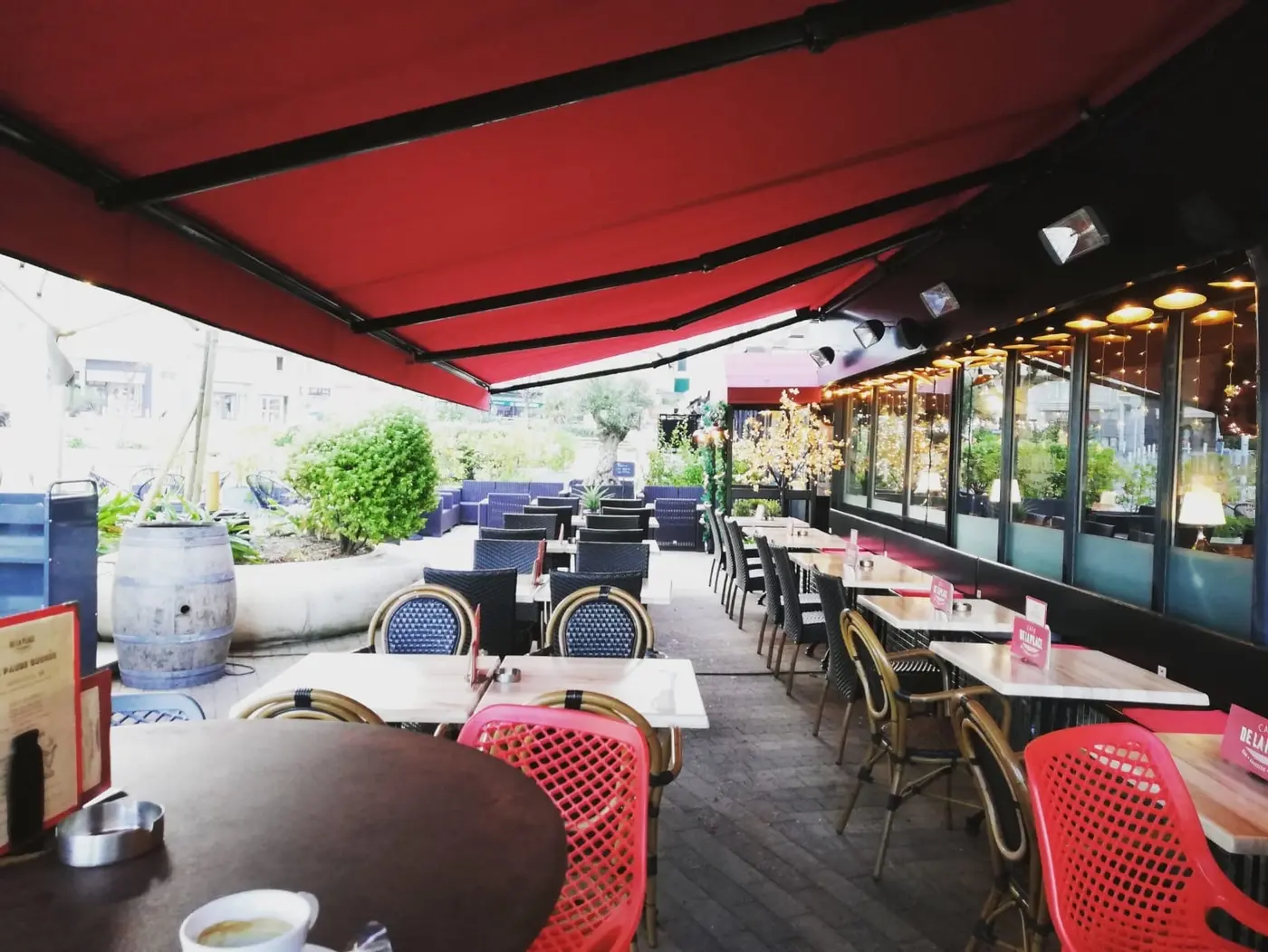 Store rouge déployé au-dessus de la terrasse du Café de la Place à Biarritz