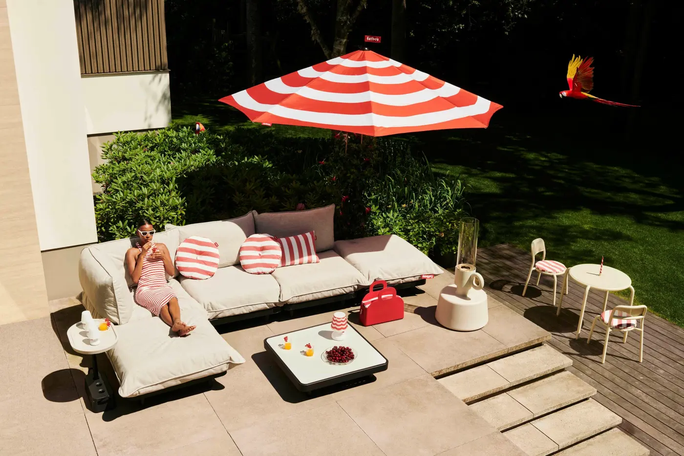 Parasol à rayures rouges et blanches au-dessus d'un canapé d'extérieur sur une terrasse