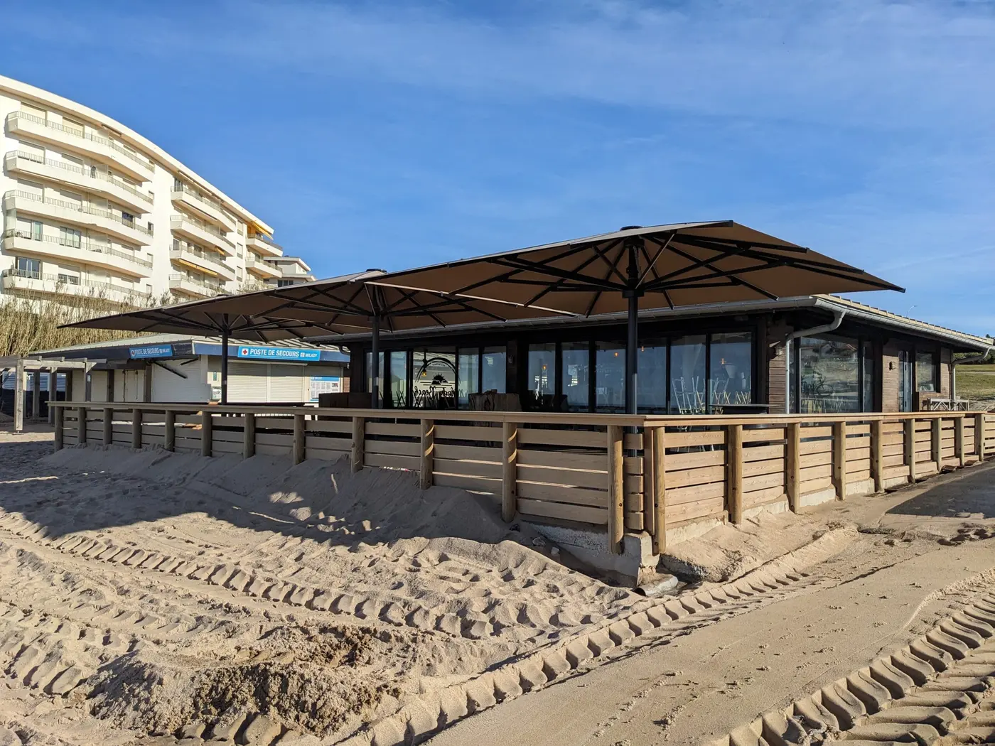 Grands parasols posés sur la terrasse du Milady Beach, sur le sable à Biarritz