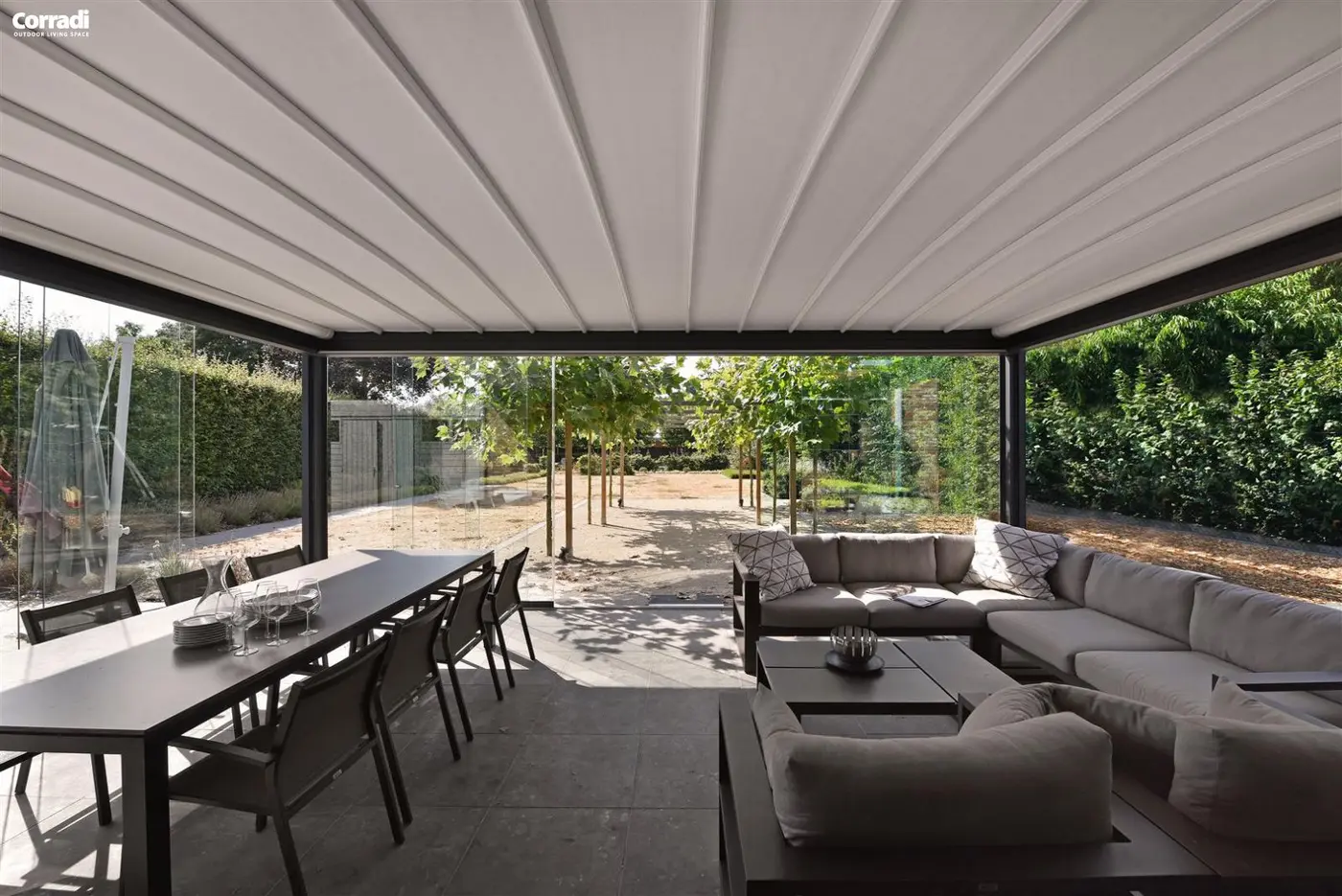 Pergola à toit en toile repliable au-dessus d'une grande table et d'un salon d'extérieur