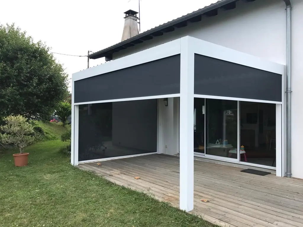 Pergola blanche avec stores verticaux toile fermés sur deux côtés, à Mouguerre