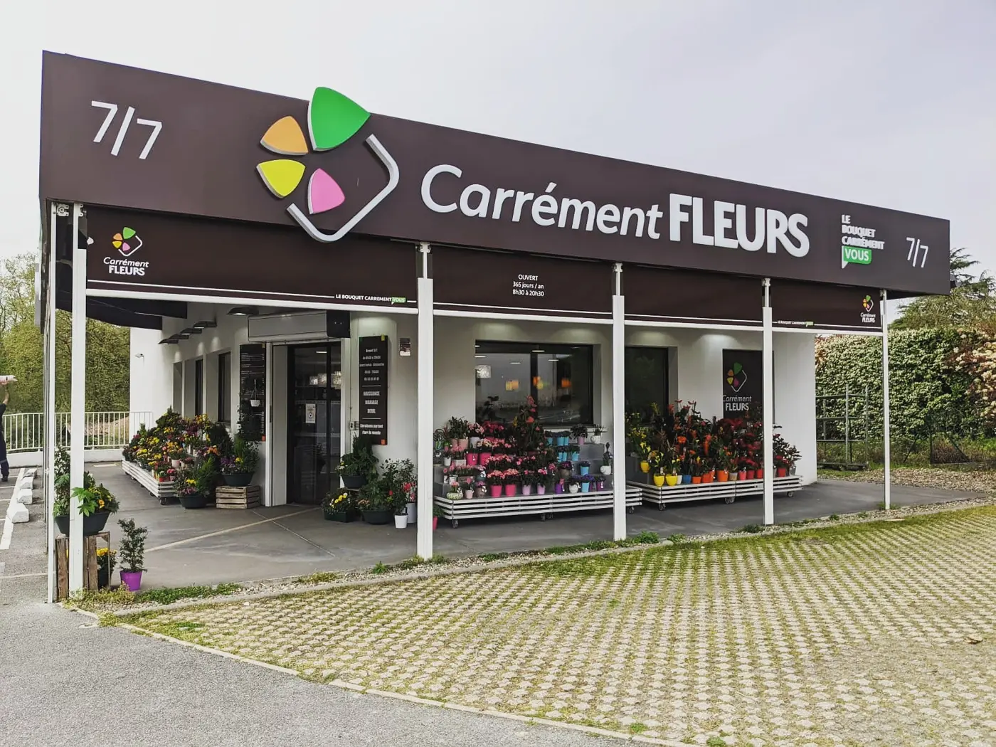 Longue toile marron imprimée au nom de Carrément Fleurs au-dessus du magasin à Bayonne