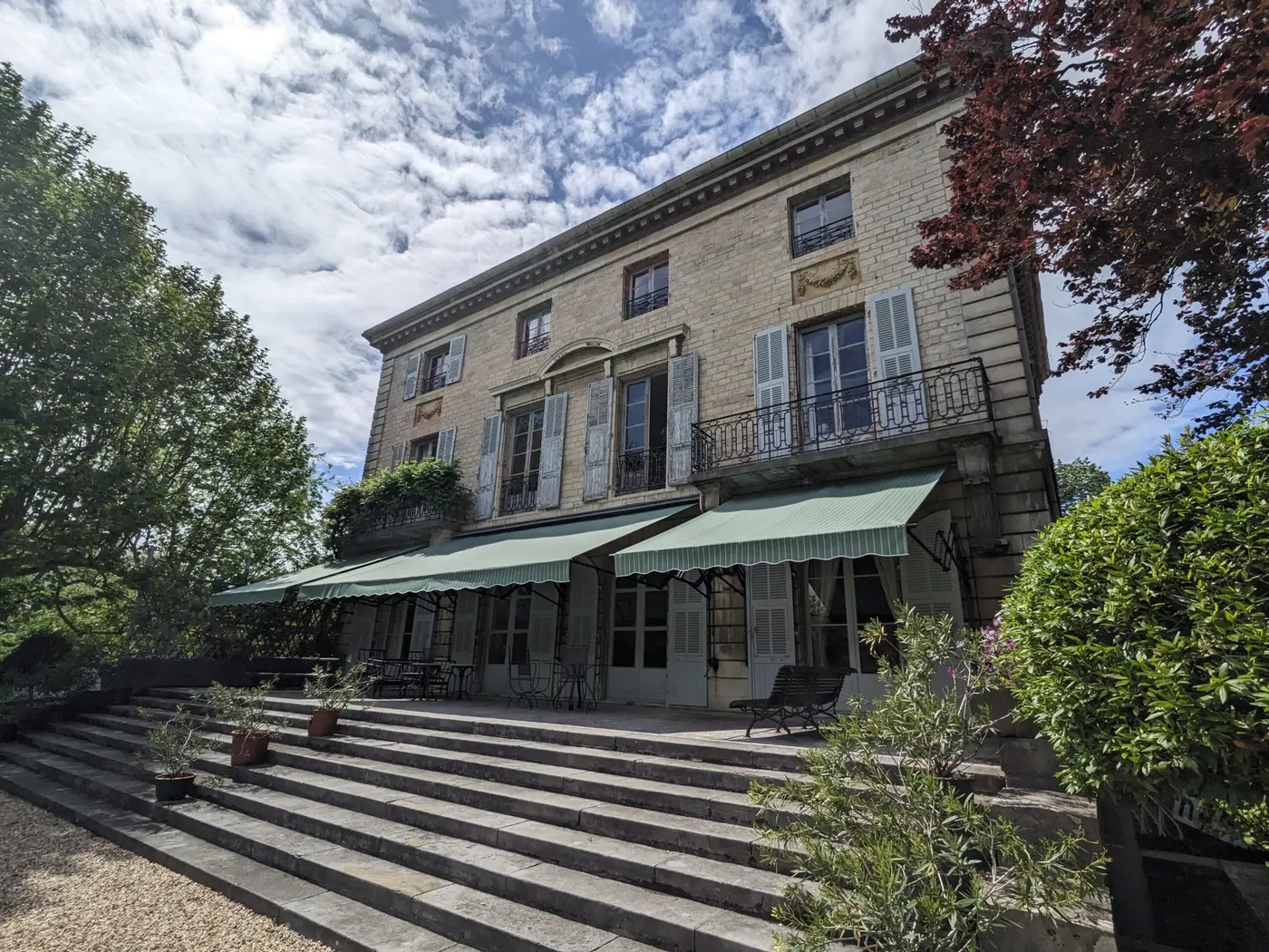 Stores à croisillons verts sur la façade d'une grande maison ancienne à Biarritz