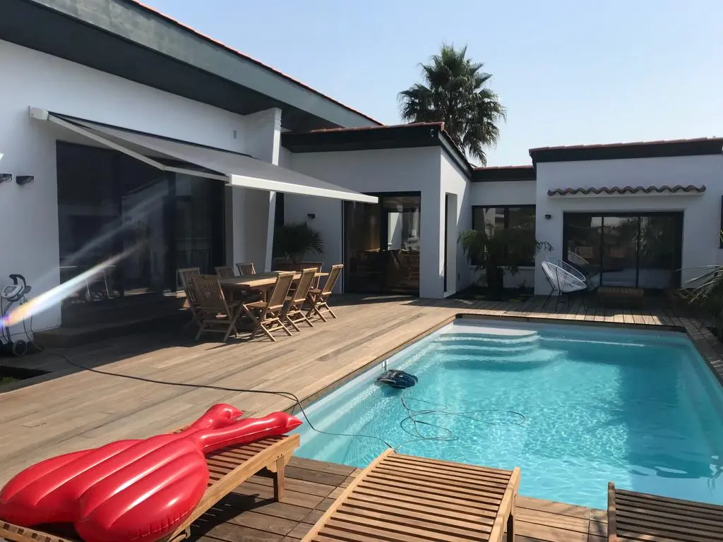 Store banne gris au-dessus d'une terrasse de piscine