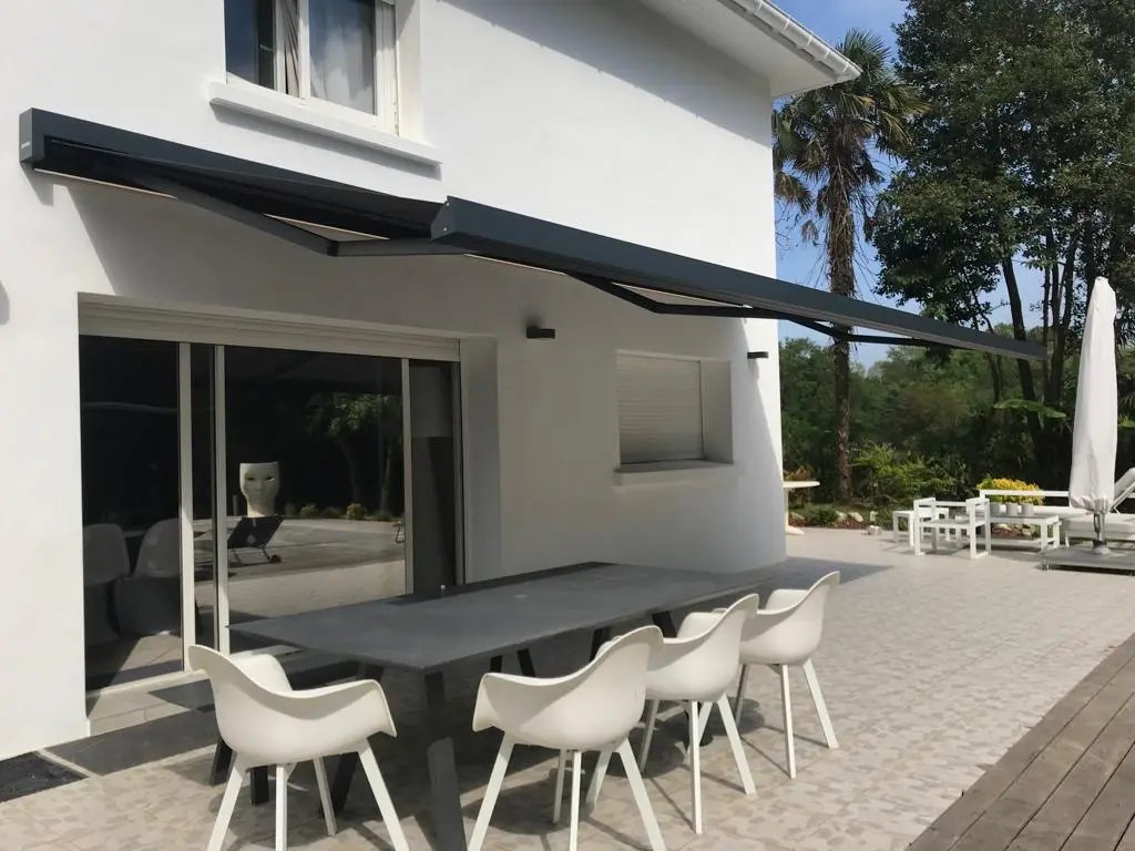 Store coffre Harol anthracite au-dessus d'une grande table de terrasse