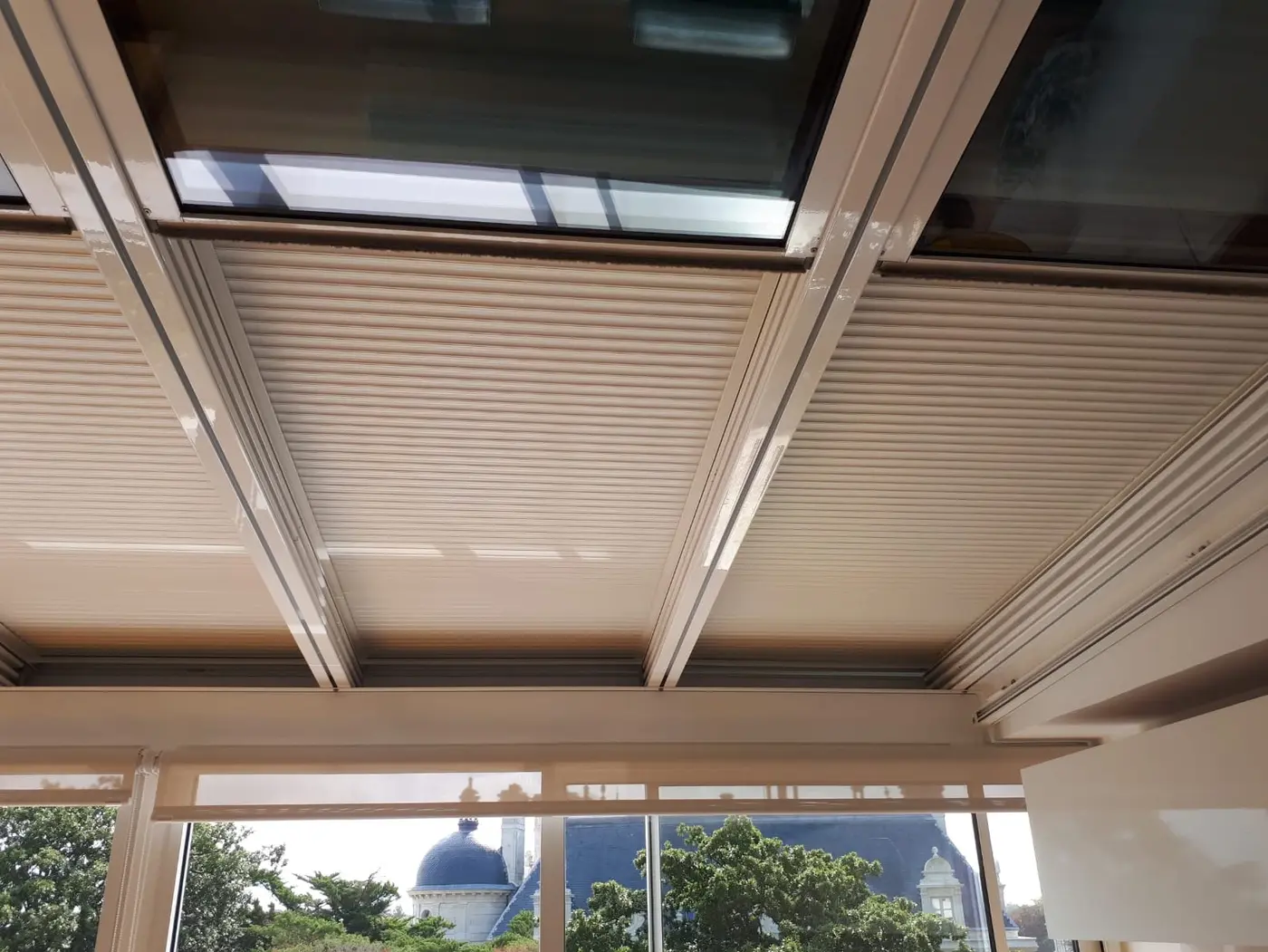 Volet roulant électrique posé sous une verrière, vu de l'intérieur