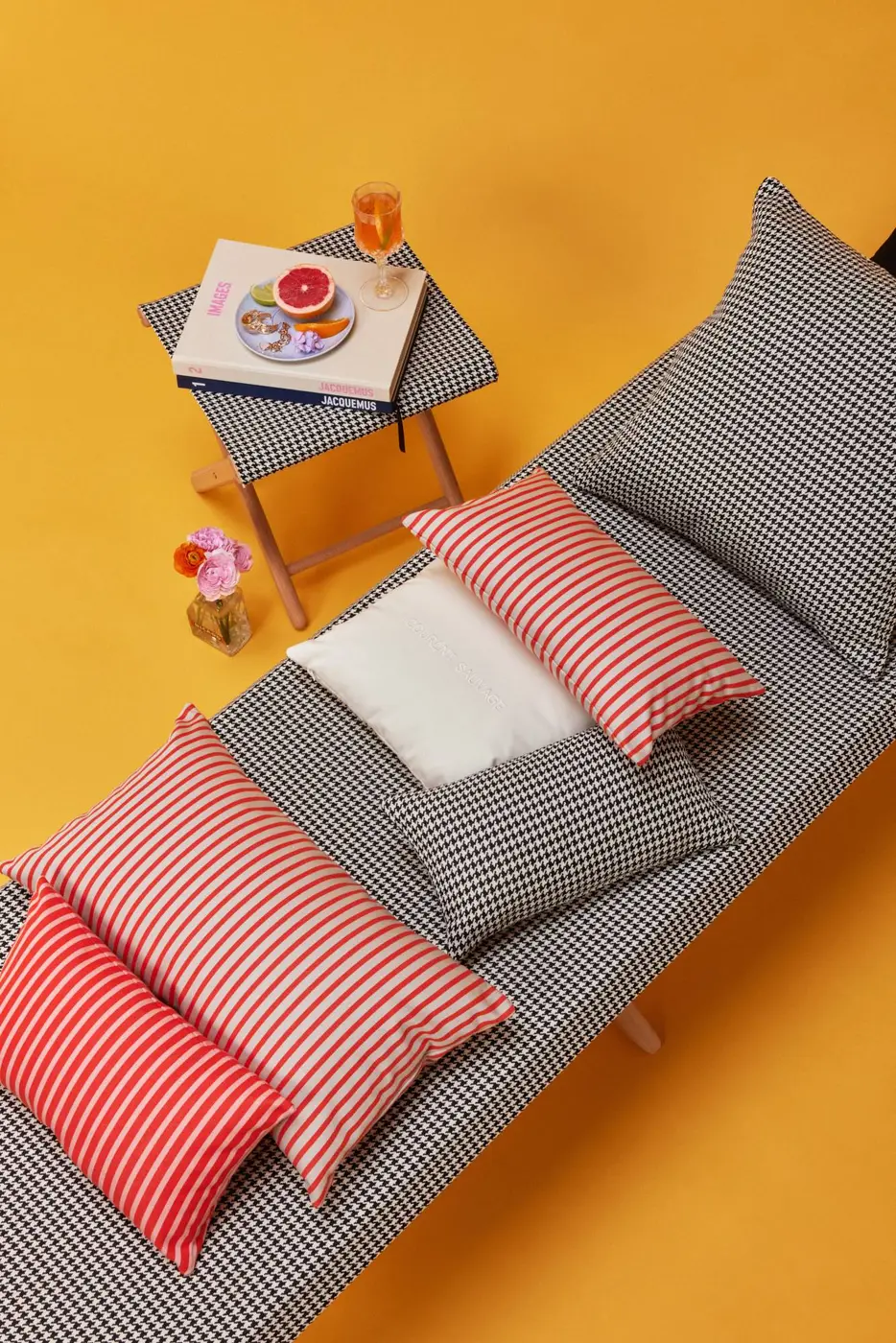 Banquette à rayures avec coussins rouges et blancs, vue du dessus sur fond jaune