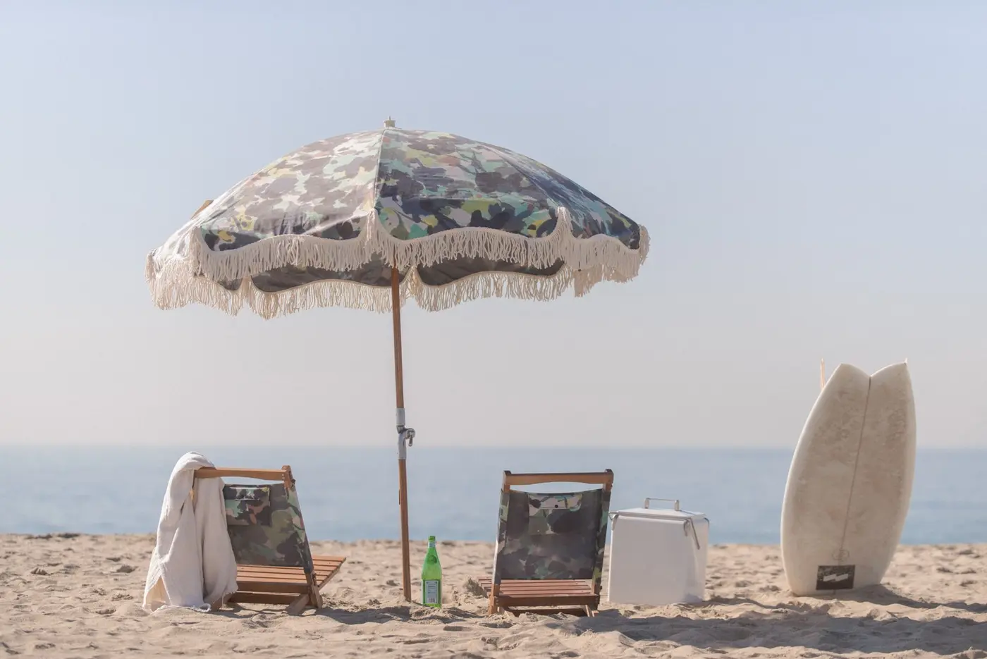 Parasol à franges et chiliennes sur une plage
