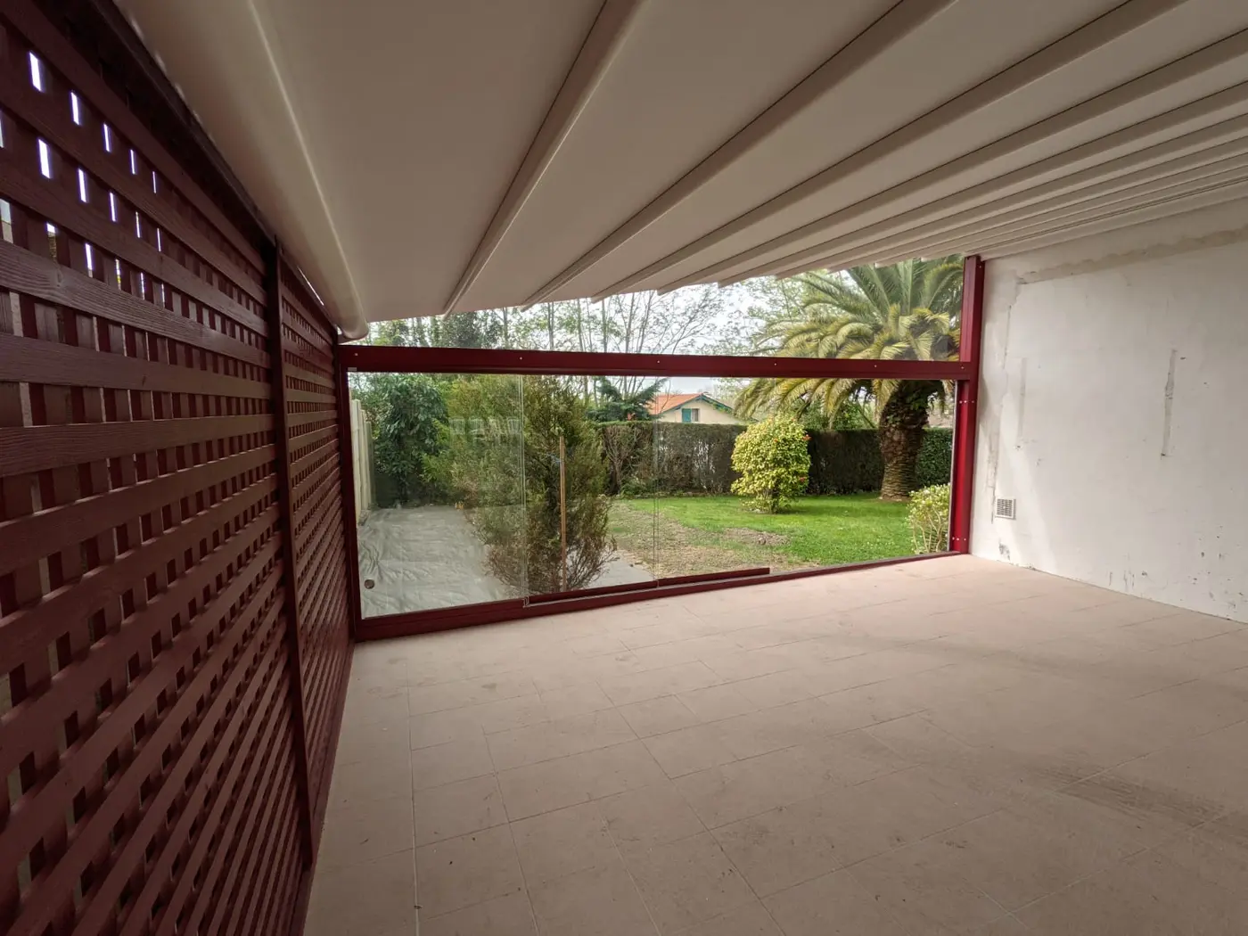 Pergola à toile blanche, avec brise-vue en bois rouge